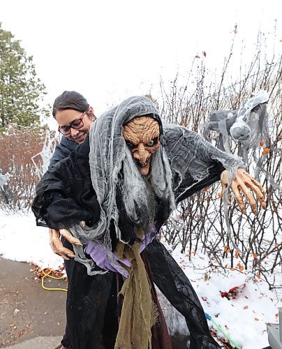 Carla Mitchell positions a wicket witch display outside their home at 29 Cedar Bay in Brandon. (Matt Goerzen/The Brandon Sun)