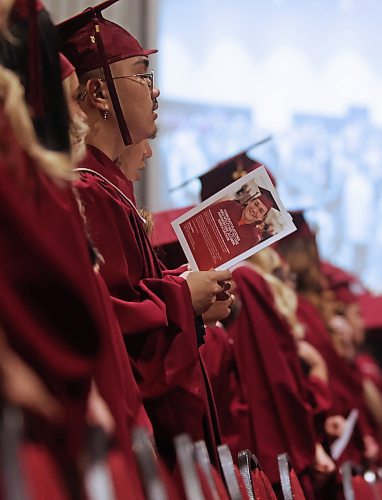 A graduating Assiniboine Community College student stands for the playing of O Canada before receiving his degree during Friday's graduation ceremony at the Keystone Centre's Manitoba Room. (Matt Goerzen/The Brandon Sun)