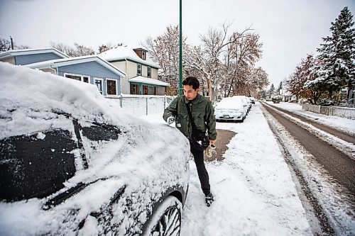 MIKAELA MACKENZIE / WINNIPEG FREE PRESS

Perry Nguyen cleans snow off of his vehicle with his sleeve before going to work in Winnipeg on Friday, Oct. 27, 2023. Standup.
Winnipeg Free Press 2023.