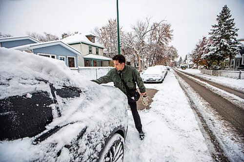 MIKAELA MACKENZIE / WINNIPEG FREE PRESS

Perry Nguyen cleans snow off of his vehicle with his sleeve before going to work in Winnipeg on Friday, Oct. 27, 2023. Standup.
Winnipeg Free Press 2023.