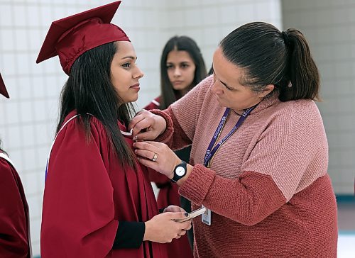 Shannon Bowers with Assiniboine Community College adjusts the gown of Sukhpreet Kaur, who graduated on Friday with an Office Skills diploma at a ceremony in the Keystone Centre's Manitoba Room. (Matt Goerzen/The Brandon Sun)
