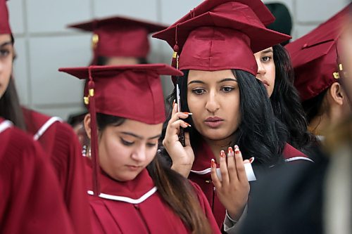 A graduating Assiniboine Community College student makes a final phone call while waiting in line prior to Friday's graduation ceremony at the Keystone Centre's Manitoba Room. (Matt Goerzen/The Brandon Sun)