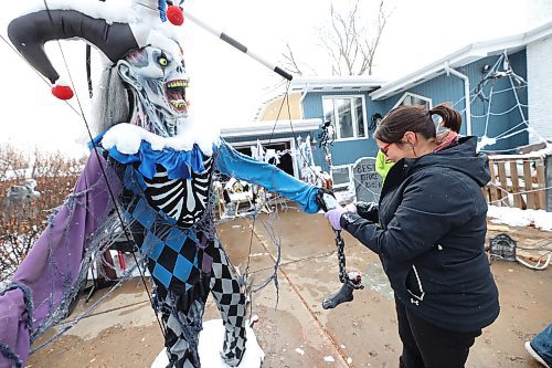 Carla Mitchell takes the snow off one of their lifesize Halloween displays outside their home at 29 Cedar Bay in Brandon. Carla and her husband Mike, who call their haunted house event Cedar Hollow Scare Away Hunger, are asking visitors to bring a food bank donation if they are able. All donations the Mitchells collect will go to Samaritan House Ministries in Brandon. (Matt Goerzen/The Brandon Sun)