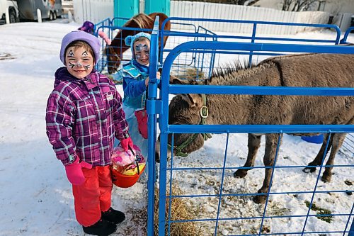 Autumn McCannell (left) and Olivia Ripmeester (right) make friends with a donkey at Calvary Temple's Halloween Parking Lot Party on Sunday afternoon. Kids and parents alike played games, got their faces painted, showed off their Halloween costumes and — perhaps most importantly — picked up some treats. (Colin Slark/The Brandon Sun)