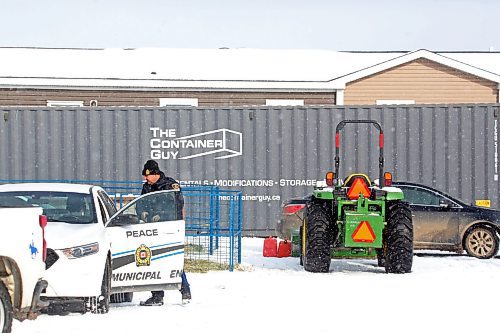 An officer with Prairie Bylaw Enforcement enters a PBE vehicle at the property of Zak McDermot-Fouts, north of Beresford in the RM of Whitehead on Monday morning. (Matt Goerzen/The Brandon Sun)
