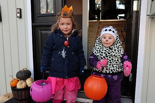 MacKenzie Allen-Loane and Sadie Vodden pick up their treats at 1105 3rd Street North during Tuesday's Halloween festivities. (Abiola Odutola/The Brandon Sun).