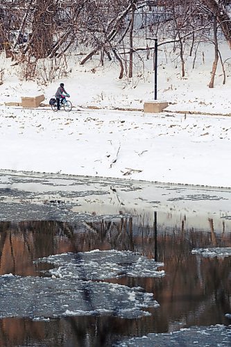 MIKE DEAL / WINNIPEG FREE PRESS
A cyclist makes their way along the Assiniboine Riverwalk Tuesday morning as ice can be seen forming on the river.
231031 - Tuesday, October 31, 2023.