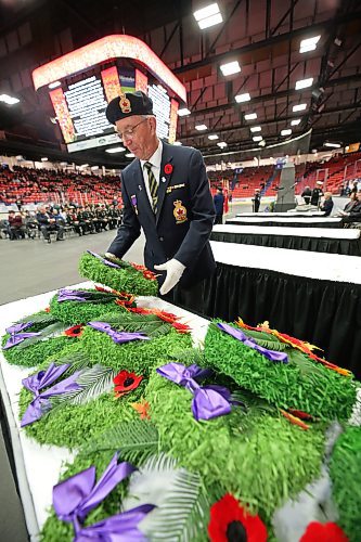 A Legion member picks up a wreath during the Remembrance Day ceremony at Brandon's Keystone Centre Friday morning. (Matt Goerzen/The Brandon Sun)