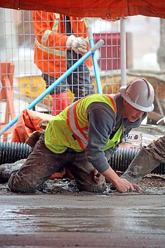 Ben Wiebe Construction employee Cole Lockhart smooths out a newly-poured sidewalk in the 1200 block of Rosser Avenue on Friday afternoon. (Matt Goerzen/The Brandon Sun)