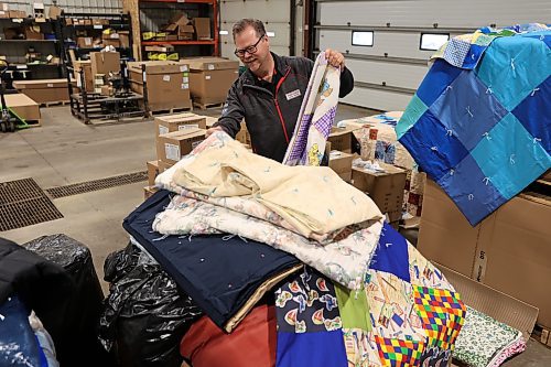 Dwayne Stone, branch manager at Premier Truck Group in Brandon, is all smiles as he sorts through some of the blankets that were donated during the one-day fundraising blitz called Fill the Freightliner, held in October. (Michele McDougall/The Brandon Sun)
