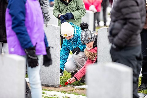 MIKAELA MACKENZIE / WINNIPEG FREE PRESS

John W. Gunn Middle School grade six students (and Ukrainian newcomers) Ustyna Shulhan (left) and Katyrina Kulish from River East Transcona School Division put poppies on a grave at a No Stone Left Alone remembrance ceremony at Transcona Cemetery on Monday, Nov. 6, 2023. 
Winnipeg Free Press 2023.