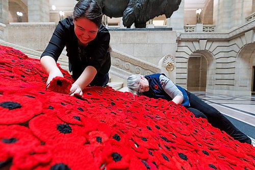 MIKE DEAL / WINNIPEG FREE PRESS
The Poppy Blanket creator, Sheila Lee Restall (left) and Susan Wakeman (right), one of the volunteers that help maintain the Poppy Blanket, reattach handmade poppies to the blanket on the Grand Staircase Monday morning.
First unveiled in November of 2019 the Poppy Blanket is an 85 foot long collection of over 8000 handmade poppies and thousands of dedicated ribbons. It was made in less than a year between 2018 and 2019 by the Handmade Winnipeg Facebook group community.
231106 - Monday, November 06, 2023.