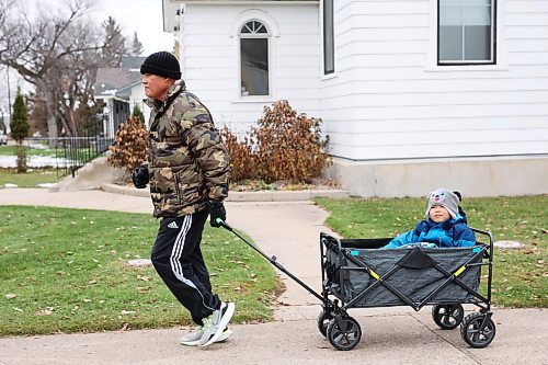 June Manjares jogs while pulling his grandson Matteo-Luis Manjares, five, along a sidewalk in Brandon’s east end on a grey Monday. (Tim Smith/The Brandon Sun)
