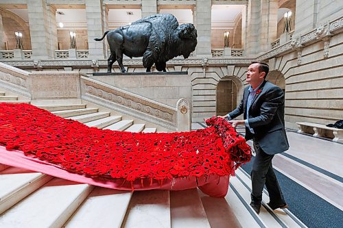 MIKE DEAL / WINNIPEG FREE PRESS
Brad Robertson, Manitoba&#x2019;s Chief of Protocol, pulls the Poppy Blanket down the last few steps of the Grand Staircase, Monday morning.
First unveiled in November of 2019 the Poppy Blanket is an 85 foot long collection of over 8000 handmade poppies and thousands of dedicated ribbons. It was made in less than a year between 2018 and 2019 by the Handmade Winnipeg Facebook group community.
231106 - Monday, November 06, 2023.