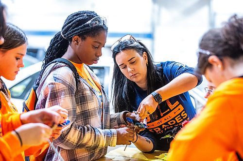 MIKAELA MACKENZIE / WINNIPEG FREE PRESS

Auto body instructor Meghan Connor helps grade nine Windsor Park Collegiate student Daisy Adesokan tighten up a sheet metal flower in the auto body shop at the Jill of All Trades event (which encourages girls to enter the trades) on Wednesday, Nov. 8, 2023. For Maggie story.
Winnipeg Free Press 2023.
