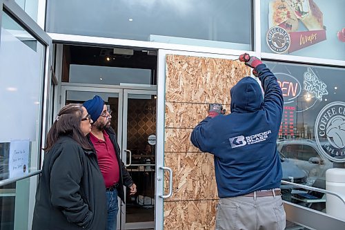 BROOK JONES / WINNIPEG FREE PRESS
The Coffee Culture Caf&#xe9; and Eatery at 2864 Pembina Highway in Winnipeg, Man., was broken into Sunday, Nov. 5, 2023. PIctured: Co-owners Sandeep Mehendiratta a (Left) nd her husband Paramjeet Mehendiratta watch as Curtis Talbot (right) from Border Glass &amp; Aluminum takes off the temporary sheet of wood covering the broken doorlight.