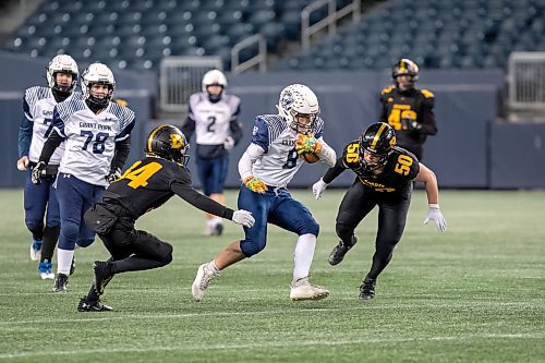 BROOK JONES / WINNIPEG FREE PRESS
The Dakota Collegiate Lancers earned a 28-7 victory over the Grand Park High School Pirates in the Winnipeg High School Football League AAAA Final of the ANAVETS Bowl at IG Field in Winnipeg, Man., Friday, Nov. 10, 2023. Pictured: Grant Park Pirates wide receiver Brock Greaves (No. 50) runs with the football as Dakota Lancers defensive lineman Destiny Okedera (No. 44) and teammate linebacker Kresten Neufeld (No. 50) try to tackle him during fourth quarter action.