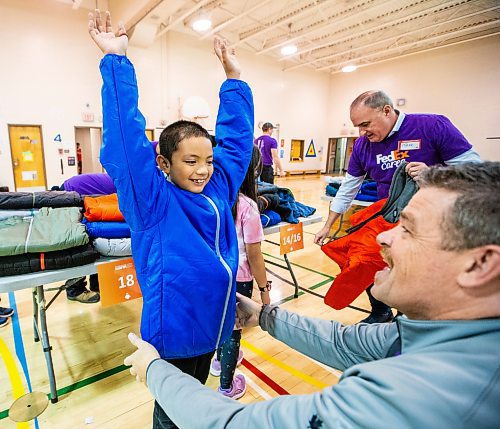 MIKAELA MACKENZIE / WINNIPEG FREE PRESS

FedEx Cares volunteer Jeff Mensies helps nine-year-old Jade Baldez-Jubinville try on a coat at Wellington School on Friday, Nov. 10, 2023. Operation Warm (a national non-profit that manufactures brand-new, high-quality coats and shoes for children in need) provided more than 300 new winter coats to the school. Standup.
Winnipeg Free Press 2023.