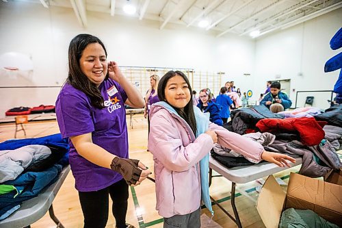 MIKAELA MACKENZIE / WINNIPEG FREE PRESS

FedEx Cares volunteer Jenn Aquino helps nine-year-old Cacey Robles try on a coat at Wellington School on Friday, Nov. 10, 2023. Operation Warm (a national non-profit that manufactures brand-new, high-quality coats and shoes for children in need) provided more than 300 new winter coats to the school. Standup.
Winnipeg Free Press 2023.