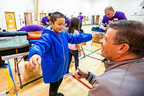 MIKAELA MACKENZIE / WINNIPEG FREE PRESS

FedEx Cares volunteer Jeff Mensies helps nine-year-old Jade Baldez-Jubinville try on a coat at Wellington School on Friday, Nov. 10, 2023. Operation Warm (a national non-profit that manufactures brand-new, high-quality coats and shoes for children in need) provided more than 300 new winter coats to the school. Standup.
Winnipeg Free Press 2023.