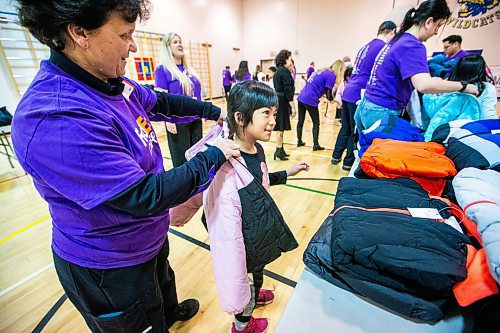 MIKAELA MACKENZIE / WINNIPEG FREE PRESS

FedEx Cares volunteer Christine Zerdin helps eight-year-old Juvana Laggansua try on a coat at Wellington School on Friday, Nov. 10, 2023. Operation Warm (a national non-profit that manufactures brand-new, high-quality coats and shoes for children in need) provided more than 300 new winter coats to the school. Standup.
Winnipeg Free Press 2023.
