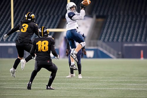 BROOK JONES / WINNIPEG FREE PRESS
The Dakota Collegiate Lancers earned a 28-7 victory over the Grant Park High School Pirates in the Winnipeg High School Football League AAAA Final of the ANAVETS Bowl at IG Field in Winnipeg, Man., Friday, Nov. 10, 2023. Pictured: Grant Park Pirates wide receiver Brock Greavers (No. 8) leaps in the air to catch a pass from his teammmate and quarterback Scott Sissson as Dakota Lancers linebacker Noah McCorriston (No. 3) and his teammate defensive back Augustine Nkundimana (No. 18) watch during fourth quarter action.