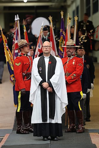 Flanked by members of the RCMP dressed in their Red Serge and stetsons, Father Chris Arthur waits for the start of Brandon's Remembrance Day ceremony on Saturday morning at the Keystone Centre. (Matt Goerzen/The Brandon Sun)