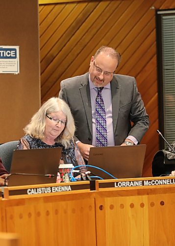 Denis Labossiere, secretary treasurer of the Brandon School Division, looks on as newly sworn-in Ward 2 trustee Lorraine McConnell signs on at a special school board meeting Monday night. (Kyla Henderson/The Brandon Sun)