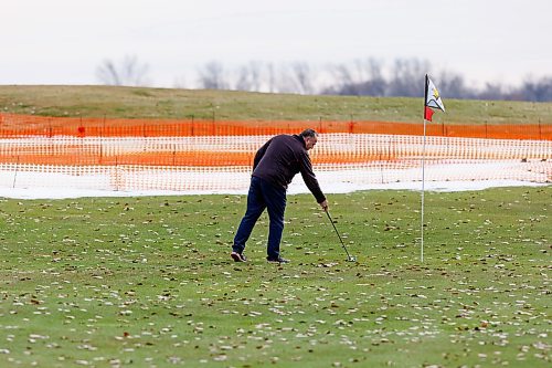 MIKE DEAL / WINNIPEG FREE PRESS
Golfer Dragan Velaja tries to clear a path for his put during an afternoon round at Southside Golf Course which opened its course because of the warm weather. 
All the courses greens were fenced off for the winter leaving greens with pins set up in the fairways.
See Kevin Rollason story
231113 - Monday, November 13, 2023.