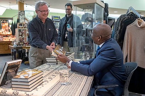 BROOK JONES / WINNIPEG FREE PRESS
Donovan Bailey (right) handing an autograph copy of his book to Winnipeg resident Brian Flynn, who is a son-in-law of the late Jim Daly, who was instrumental in bringing the 1967 Pan American Games to Winnipeg, during his book launch at McNally Robinson in Winnipeg, Man., Wednesday, Nov. 15, 2023. An Evening with Donovan Bailey was hosted by 103.1 Virgin Radio personality Ace Burpee. Bailey, who is an Olympian in the sport of athletics (track &amp; field) and won double gold at the 1996 Summer Olympic Games in Atlanta, Ga., was in Winnipeg promoting his book called Undisputed.
