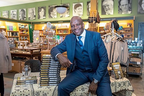 BROOK JONES / WINNIPEG FREE PRESS
Donovan Bailey smiling as he sits next to a stack of books at his book launch at McNally Robinson in Winnipeg, Man., Wednesday, Nov. 15, 2023. An Evening with Donovan Bailey was hosted by 103.1 Virgin Radio personality Ace Burpee. Bailey, who is an Olympian in the sport of athletics (track &amp; field) and won double gold at the 1996 Summer Olympic Games in Atlanta, Ga., was in Winnipeg promoting his book called Undisputed.