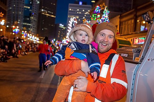 BROOK JONES / WINNIPEG FREE PRESS
Manitoba Hydro employee Brett holding his daughter Rae while they participate in the Manitoba Hydro Santa Claus Parade in Winnipeg, Man., Saturday, Nov. 18, 2023. The Santa Claus parade has run annually in Winnipeg since the former Eaton&#x2019;s department store organized the first one in 1909.