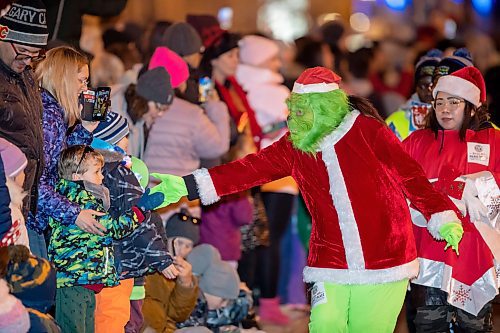 BROOK JONES / WINNIPEG FREE PRESS
The Grinch giving high fives to children during the Manitoba Hydro Santa Claus Parade in Winnipeg, Man., Saturday, Nov. 18, 2023. The Santa Claus parade has run annually in Winnipeg since the former Eaton&#x2019;s department store organized the first one in 1909.