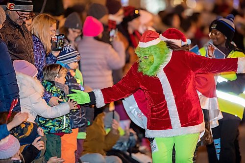 BROOK JONES / WINNIPEG FREE PRESS
The Grinch giving high fives to children during the Manitoba Hydro Santa Claus Parade in Winnipeg, Man., Saturday, Nov. 18, 2023. The Santa Claus parade has run annually in Winnipeg since the former Eaton&#x2019;s department store organized the first one in 1909.