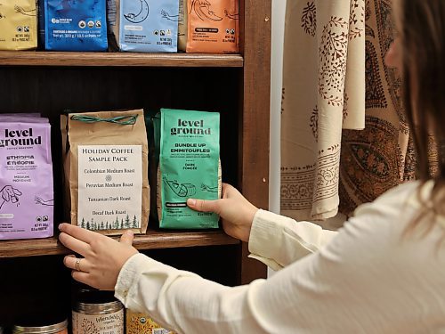 Stephanie De la Luz, Ten Thousand Villages Brandon store manager stocks the shelves with Level Ground fair-trade coffee on Wednesday. (Michele McDougall/The Brandon Sun)

