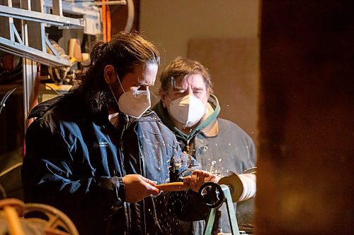 BROOK JONES / WINNIPEG FREE PRESS
Bill Gidzak and his son Nick run a woodworking shop called Artisanal Firewood. The father-and-son team turn out a variety of products, especially Christmas theme decorations and toys for kids. Pictured: Nick (left) operating a wood turning lathe as his father Bill looks on. The duo were pictured woodworking inside Bill's garage at his home in Winnipeg, Man., Wednesday, Nov. 22, 2023.
