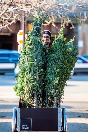 MIKAELA MACKENZIE / WINNIPEG FREE PRESS

Garrett Everett with Winnipeg Trails transports balsam firs from storage to the Christmas Tree stand using a cargo bike at The Forks on Friday, Nov. 24, 2023. All of the proceeds from the sale, which starts today, are going towards the Future Forest initiative (which plants trees along trails in Winnipeg and surrounding areas). Standup.
Winnipeg Free Press 2023.