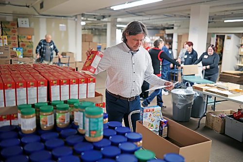 27112023
Brandon Mayor Jeff Fawcett packs a Christmas hamper at the Brandon-Westman Christmas Cheer Registry in downtown Brandon on Monday afternoon. The registry is urging Brandonites to adopt a family so they can fulfil a surplus of hamper requests. (Tim Smith/The Brandon Sun)