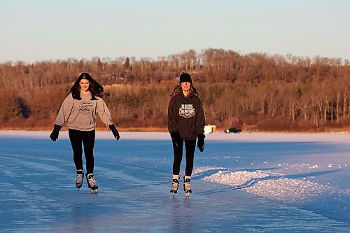 28112023
Friends Alexandria Singh and Shelby Hynes ice skate together on a cleared trail along the western side of Minnedosa Lake at sunset on a sunny and mild Tuesday. 
(Tim Smith/The Brandon Sun)