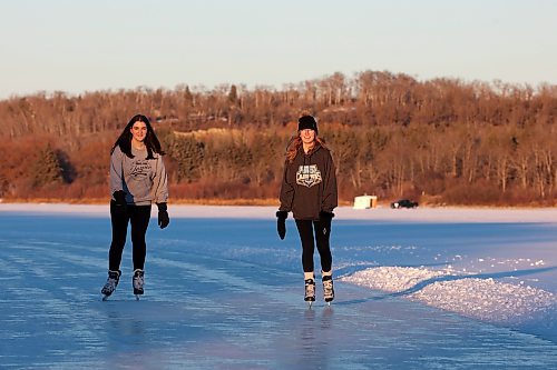 28112023
Friends Alexandria Singh and Shelby Hynes ice skate together on a cleared trail along the western side of Minnedosa Lake at sunset on a sunny and mild Tuesday. 
(Tim Smith/The Brandon Sun)