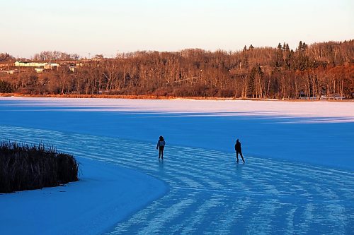 28112023
Friends Alexandria Singh and Shelby Hynes ice skate together on a cleared trail along the western side of Minnedosa Lake at sunset on a sunny and mild Tuesday. 
(Tim Smith/The Brandon Sun)