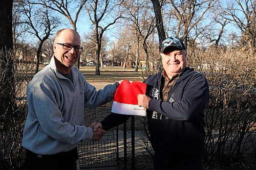 Longtime Santa Parade organizer Karlheinz Sawatzky-Dyck (left) hands over the key to the parade to Gladden Smith, chair of the Westman and Area Traditional Christmas Dinner. (Abiola Odutola/The Brandon Sun)