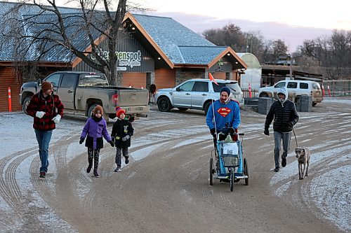 Dressed as Superman, Jon Nabbs kicks off a Brandon leg of his cross-country marathon at The Green Spot with the family of owner Bernie Whetter on Friday morning. (Colin Slark/The Brandon Sun)