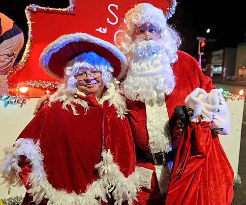 Mr. and Mrs. Claus pose for a photo before climbing up onto the Santa sleigh that is traditionally placed at the end of the Brandon Santa Parade. (Abiola Odutola/The Brandon Sun)