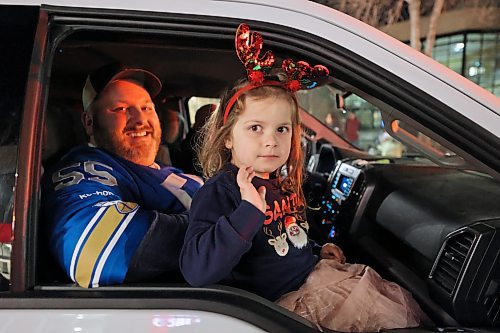 A young girl with festive antlers waves to the camera from inside a vehicle in the Brandon Santa Parade. (Abiola Odutola/The Brandon Sun)