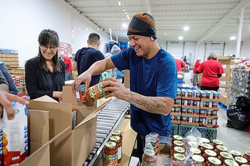 RUTH BONNEVILLE / WINNIPEG FREE PRESS

Local -  Christmas Cheerboard Story

Photo of Jeremy Hall (hat, turquoise shirt) working packing food hampers with his group from Native Clan along the line at the Christmas Cheer warehouse Thursday. 

Feature at the warehouse speaking to volunteers on the sense of community that they feel.
 
CHEER BOARD: Every year the Cheer Board sets up for the massive undertaking of receiving, building and sending out over 18,000 hampers to families in need. Before the phone lines even open, volunteers have already been busy for weeks building a functional warehouse space, receiving food, setting up different work areas. 

See TAYLOR'S Story. 

Nov 30th,, 2023