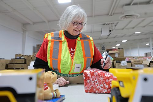 RUTH BONNEVILLE / WINNIPEG FREE PRESS

Local -  Christmas Cheerboard Story

Photo of head Elf wrapper, June Feakes who has volunteered for 32 consecutive Christmas seasons, finishing up a wrapping Thursday. 

Feature at the warehouse speaking to volunteers on the sense of community that they feel.
 
CHEER BOARD: Every year the Cheer Board sets up for the massive undertaking of receiving, building and sending out over 18,000 hampers to families in need. Before the phone lines even open, volunteers have already been busy for weeks building a functional warehouse space, receiving food, setting up different work areas. 

See TAYLOR'S Story. 

Nov 30th,, 2023