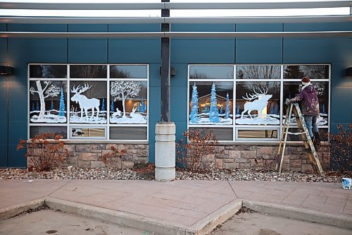 01122023
Brandon artist Anne Boychuk-Bondamann works on a holiday window mural for Westman Communications Group on Park Avenue in Brandon on Friday afternoon. 
(Tim Smith/The Brandon sun)