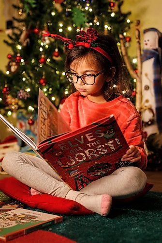 JOHN WOODS / WINNIPEG FREE PRESS
Faith reads some Christmas books at her home Tuesday, December 5, 2023. 

Reporter: ben - Christmas book front