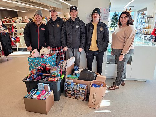 Neepawa Titans hockey players Connor Thompson, Cody Gudnason, Cade Bendtsen, Ewan Poirier and Salvation Army Director of Community Ministries Amanda Naughton-Gale stand behind a pile of presents gathered from a food drive. The toys were collected at Harris Pharmacy and at a Titans game on Dec. 5. (Miranda Leybourne/The Brandon Sun)